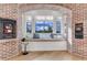 Charming breakfast nook with a fireplace, window seat and exposed brick surround at 15355 Zuni St, Broomfield, CO 80023