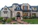 Elegant stone home with arched doorway, wooden shutters, and meticulous landscaping adding curb appeal at 15355 Zuni St, Broomfield, CO 80023