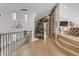 Hallway with a custom library wall, hardwood floors and winding staircase at 15355 Zuni St, Broomfield, CO 80023