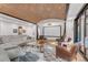 Stylish living room with exposed brick ceiling, comfortable seating, and a large screen for entertainment at 15355 Zuni St, Broomfield, CO 80023