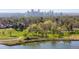 Aerial view of the neighborhood featuring lush greenery, a serene lake, and the city skyline in the distance at 3101 W 47Th Ave # 13, Denver, CO 80211