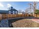 Backyard with wooden fence, stone landscaping, and view of the neighbor's blue house at 9333 Cattail Ct, Highlands Ranch, CO 80126