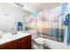 Well-lit bathroom with a vanity sink, toilet, and a shower-tub combination with a decorative shower curtain at 9333 Cattail Ct, Highlands Ranch, CO 80126