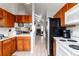 The well-lit kitchen is equipped with a black refrigerator, white countertops, and white appliances at 9333 Cattail Ct, Highlands Ranch, CO 80126