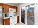 Bright kitchen features warm wood cabinetry, white appliances, and sliding door access to outdoor patio at 9333 Cattail Ct, Highlands Ranch, CO 80126