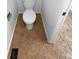 Small bathroom with toilet and brown tile flooring at 2685 S Dayton Way # 326, Denver, CO 80231