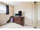 Bedroom featuring carpeted floor, neutral paint and a dresser with mounted TV for relaxation and entertainment at 7984 Chase Cir # 68, Arvada, CO 80003
