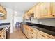 Bright kitchen features wood cabinets, sleek black countertops, tiled floor and modern stainless steel appliances at 7984 Chase Cir # 68, Arvada, CO 80003