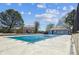 Community pool with a safety cover surrounded by concrete and trees at 7984 Chase Cir # 68, Arvada, CO 80003
