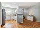 Bright, open kitchen featuring white cabinets, modern appliances, and hardwood floors at 9818 E Carolina Pl, Aurora, CO 80247