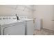 Functional laundry room with washer, dryer, and overhead shelving at 9818 E Carolina Pl, Aurora, CO 80247