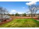 A spacious backyard features a well-maintained lawn, a wooden deck, and mature trees at 4927 Greenwich Way, Highlands Ranch, CO 80130