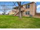 Landscaped backyard featuring a two-level wooden deck and green lawn at 4927 Greenwich Way, Highlands Ranch, CO 80130