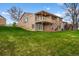 Expansive backyard with lush green lawn and a two-tiered deck with wooden stairs at 4927 Greenwich Way, Highlands Ranch, CO 80130