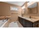 Bathroom features double sinks, granite counters, and tub for a relaxing space at 4927 Greenwich Way, Highlands Ranch, CO 80130