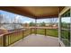 A covered wooden deck overlooking a backyard with green lawn and a wooden privacy fence at 4927 Greenwich Way, Highlands Ranch, CO 80130