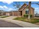 Charming brick home with a well-manicured lawn, a two-car garage and a concrete driveway at 4927 Greenwich Way, Highlands Ranch, CO 80130
