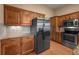 Close up of kitchen with stainless steel fridge, wood cabinets, and granite countertops at 4927 Greenwich Way, Highlands Ranch, CO 80130