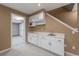 Kitchenette features white cabinetry, updated microwave and sink, and under-stair storage at 4927 Greenwich Way, Highlands Ranch, CO 80130