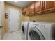 Laundry room features a side-by-side washer and dryer, tile floor, and built-in cabinets at 4927 Greenwich Way, Highlands Ranch, CO 80130