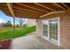 Covered brick patio with access to the backyard through white-framed glass doors at 4927 Greenwich Way, Highlands Ranch, CO 80130