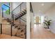 Modern staircase with metal railings and wood steps and view to front door at 2773 S Harrison St, Denver, CO 80210