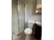 Bathroom featuring a shower with a glass door, a standard toilet, and an elegant vanity sink at 772 Victor St, Aurora, CO 80011