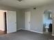 Bright bedroom with grey walls and carpet, with an ensuite bathroom and two closets for storage at 772 Victor St, Aurora, CO 80011