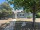 A charming single-story home with a gray exterior, surrounded by mature trees and a sidewalk leading to the entrance at 772 Victor St, Aurora, CO 80011