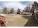 Fenced backyard showcasing an expansive grassy area and established trees at 9866 Spring Hill Ln, Highlands Ranch, CO 80129