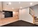 Finished basement featuring a cozy carpeted area, stairs, and an entertainment center with a dark accent wall at 9866 Spring Hill Ln, Highlands Ranch, CO 80129