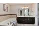 Bright bathroom featuring dual sinks, a soaking tub, and a large mirror reflecting a walk-in shower at 9866 Spring Hill Ln, Highlands Ranch, CO 80129