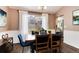 Cozy dining room features a wooden table, blue chairs, and bright natural light at 9866 Spring Hill Ln, Highlands Ranch, CO 80129