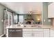 Kitchen area with stainless steel dishwasher and a view into the living room with a fireplace at 9866 Spring Hill Ln, Highlands Ranch, CO 80129