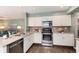 Kitchen with stainless appliances, light countertops, and open floor plan at 9866 Spring Hill Ln, Highlands Ranch, CO 80129