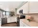 Cozy kitchen featuring white cabinetry, stainless steel appliances, and view to the living room at 9866 Spring Hill Ln, Highlands Ranch, CO 80129