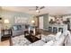 Open concept living room featuring access to the kitchen, hardwood floors, and neutral colors at 9866 Spring Hill Ln, Highlands Ranch, CO 80129
