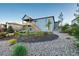 Backyard featuring lush landscaping, mulched beds, gravel pathways, and access to the covered deck at 3790 Mighty Oaks St, Castle Rock, CO 80104