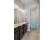 This bathroom features a granite-topped vanity with a sink and faucet and a shower and toilet in an alcove at 3790 Mighty Oaks St, Castle Rock, CO 80104