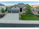 Beautiful two-story home boasts a three-car garage, red shutters, stone accents, and a well-maintained lawn at 3790 Mighty Oaks St, Castle Rock, CO 80104