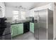 Charming kitchen featuring light green lower cabinets and white upper cabinets with stainless steel appliances at 18172 E Arizona Ave # A, Aurora, CO 80017