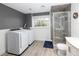 Practical laundry room with a washer and dryer, adjacent to a modern shower in the bathroom at 18172 E Arizona Ave # A, Aurora, CO 80017