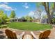 Large backyard featuring green grass, mature trees, and a covered patio at 3040 S Dexter Way, Denver, CO 80222