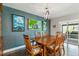 Dining room features modern lighting, hardwood floors, adjacent to sliding glass doors and colorful wall art at 3040 S Dexter Way, Denver, CO 80222