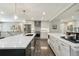 Spacious kitchen with stainless steel appliances, large island, white cabinetry, and hardwood floors at 3040 S Dexter Way, Denver, CO 80222