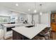 Kitchen island with seating, quartz countertops, and modern sink with pendant lighting at 3040 S Dexter Way, Denver, CO 80222
