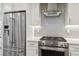 Sleek kitchen with stainless steel appliances, white cabinetry, and chevron backsplash at 3040 S Dexter Way, Denver, CO 80222