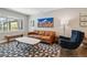 Cozy living room featuring a leather sofa, modern rug, and a bright, airy atmosphere at 3040 S Dexter Way, Denver, CO 80222
