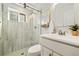 Stylish bathroom featuring a glass enclosed shower, updated fixtures, and marble wall tiles at 10699 W 9Th Pl, Lakewood, CO 80215