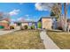 Charming home featuring a well-kept lawn, a bright green front door, and a mix of modern and classic architecture at 10699 W 9Th Pl, Lakewood, CO 80215